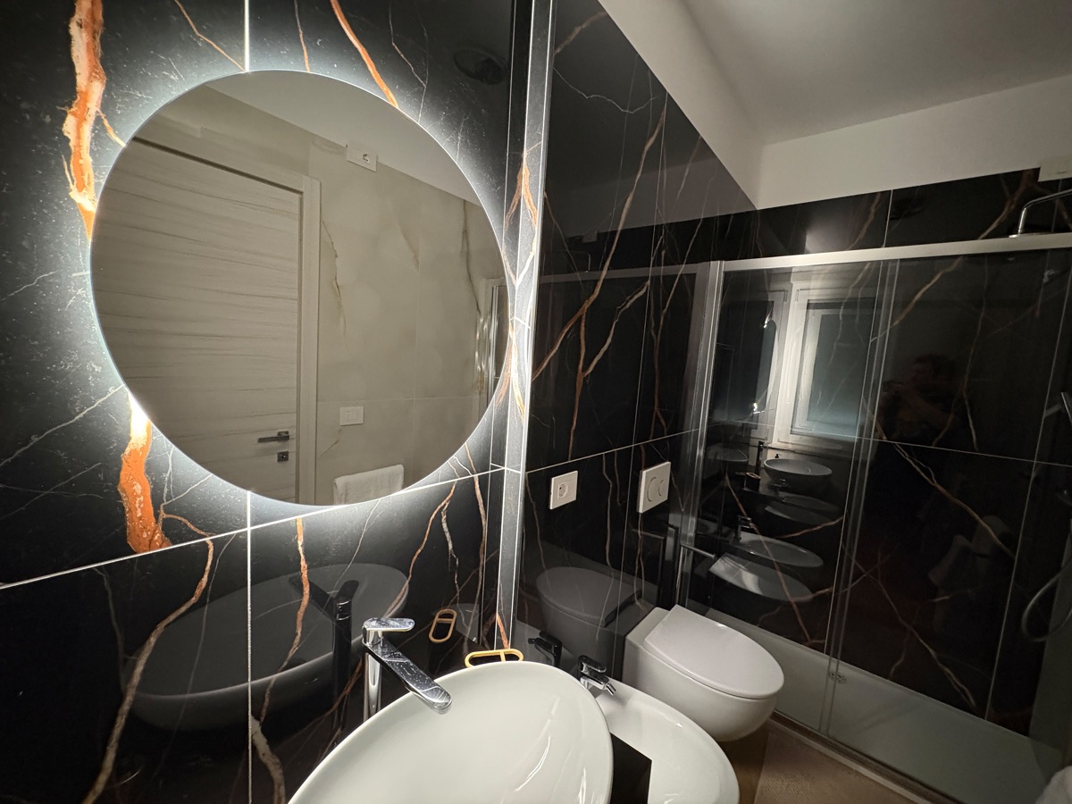Bagno in marmo nero con specchio illuminato